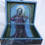 Painting: An angel playing the violin painted on the inside lid of a treasure box.