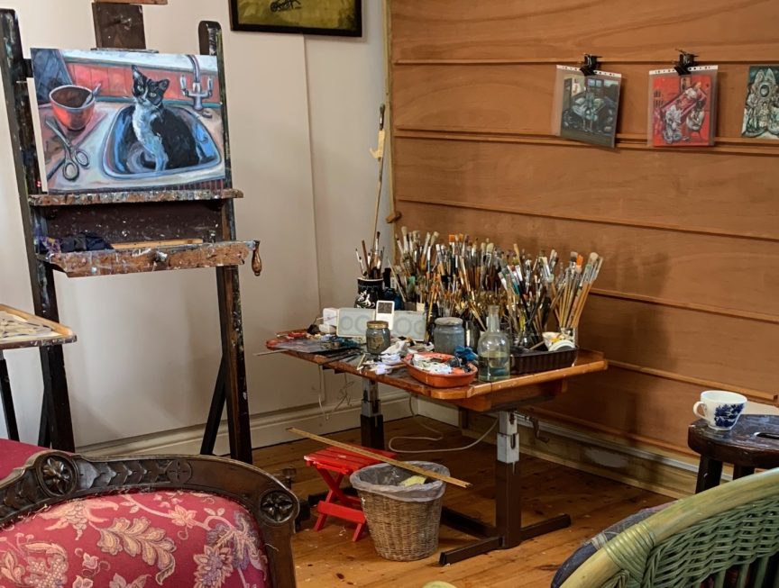 The view Inside an artists studio with a painting on an easel .